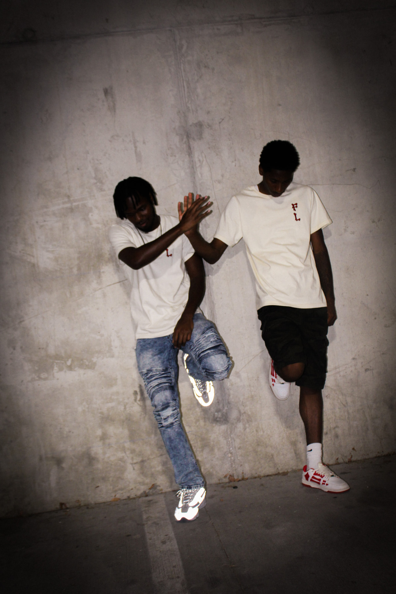 F8VRLASTING campaign: two models greeting each other by a concrete wall in crème F8VR tees
